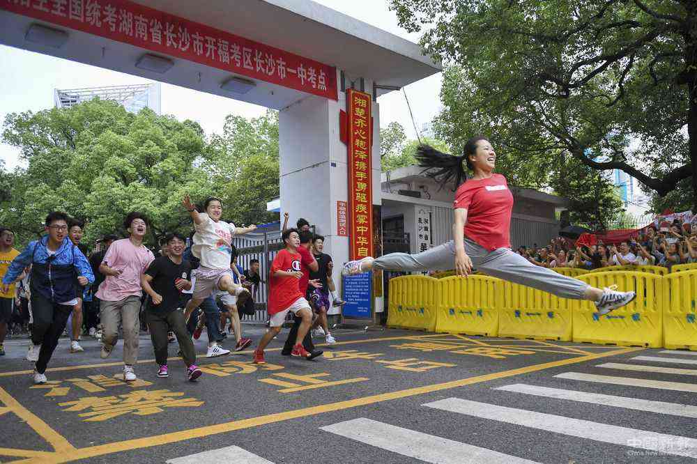 7月8日，高考結(jié)束，長(zhǎng)沙市第一中學(xué)高考考生羅子欣（右）沖出考點(diǎn)大門后以“一字馬”姿態(tài)躍起。她和小伙伴們?cè)缇图s好，要以一個(gè)特殊的方式紀(jì)念高中生活結(jié)束。新華社發(fā)（辜鵬博 攝）